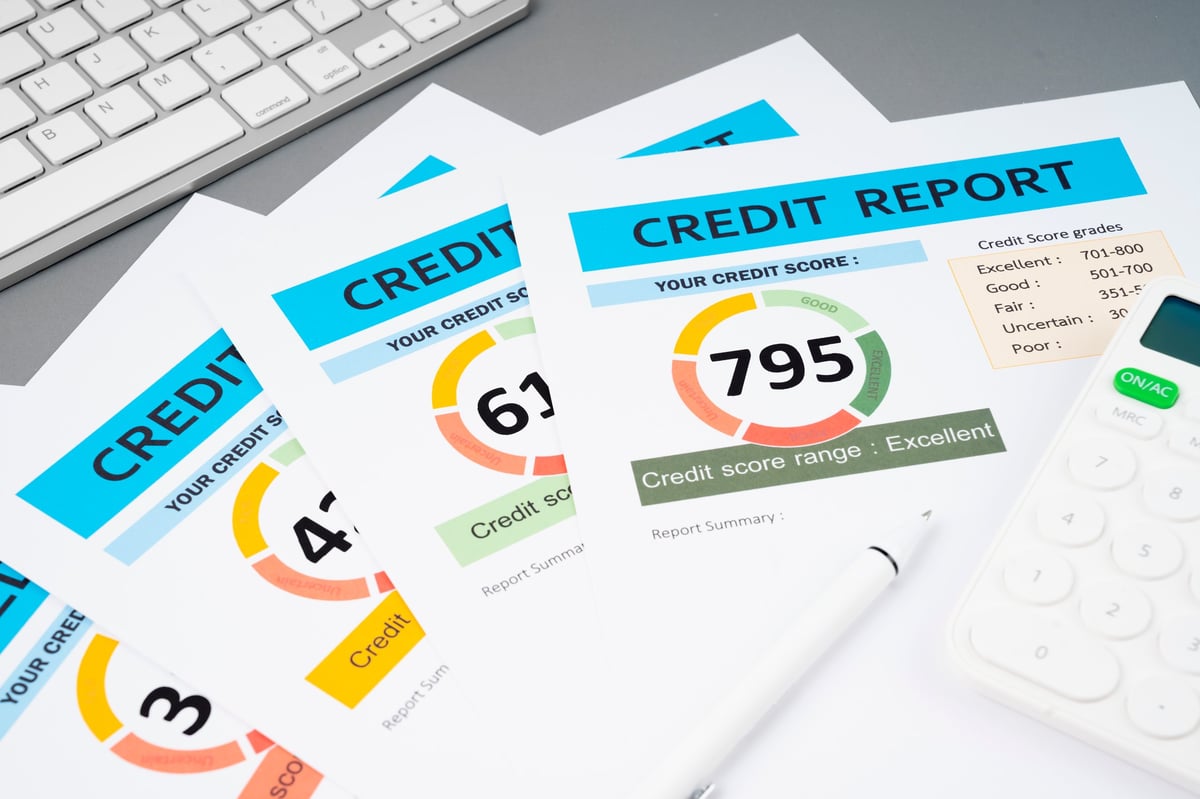 Credit score report document with pen and calculator on a desk