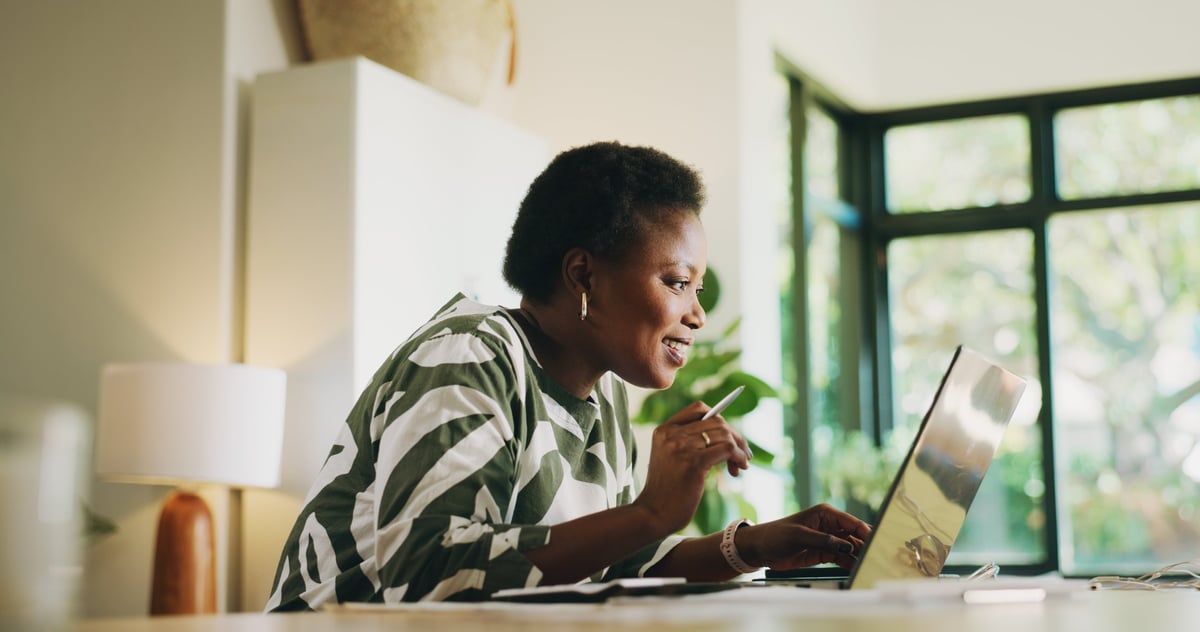 Black woman budgeting and doing taxes on a laptop at home