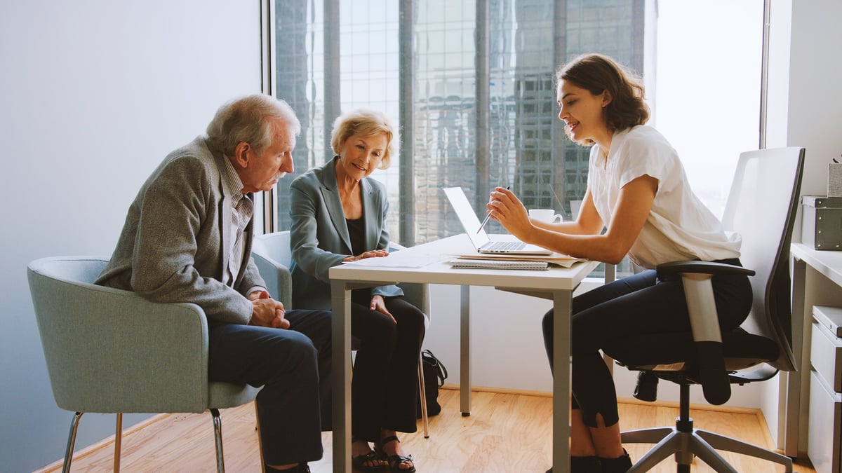 Financial advisor reviewing plans with clients in an office